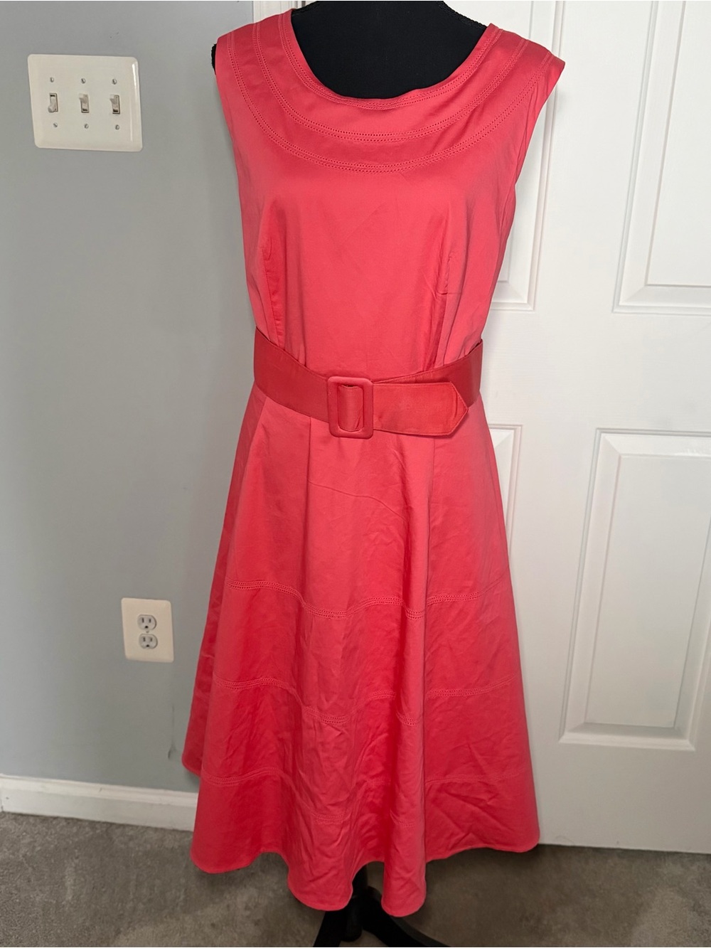 Coral colored sleeveless dress.